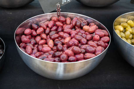 Brown Greek pickled calamata olives for sale on farmers market close up