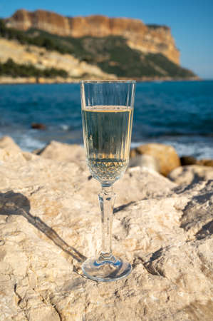 French champagne sparkling wine in glass and view on beach, blue sea water and mountains in Cassis, Provence, Franceの写真素材