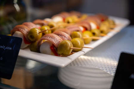 Typical snacks of Basque Country and Navarre, pinchos or pinxtos on skewers on display in bar, Bilbao, Spain, close upの写真素材