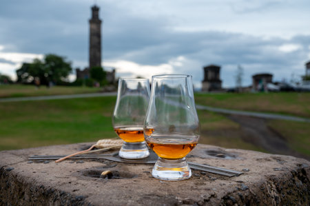 Tasting of single malt scotch whiskey in glasses with panoramic view from Calton hill to new and old parts of Edinburgh city in rainy summer day, Scotland, UKの写真素材