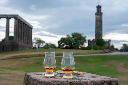 Tasting of single malt scotch whiskey in glasses with panoramic view from Calton hill to new and old parts of Edinburgh city in rainy summer day, Scotland, UKの素材 [FY310191117279]