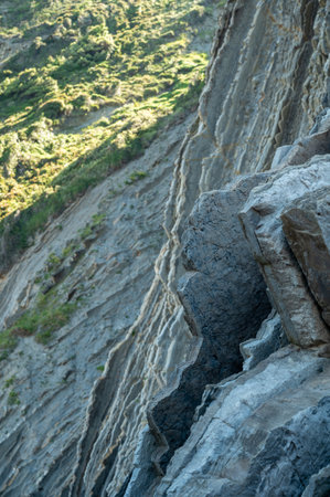 View on steeply-tilted layers of flysch geological formation on Atlantic coast at Zumaia at low...