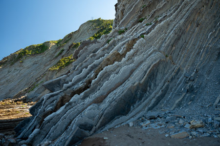 View on steeply-tilted layers of flysch geological formation on Atlantic coast at Zumaia at low...