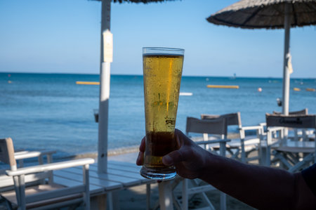 Pint of cold lager beer served outdoor in sunny beach bar on Cyprusの写真素材
