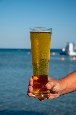 Pint of cold lager beer served outdoor in sunny beach bar on Cyprusの写真素材