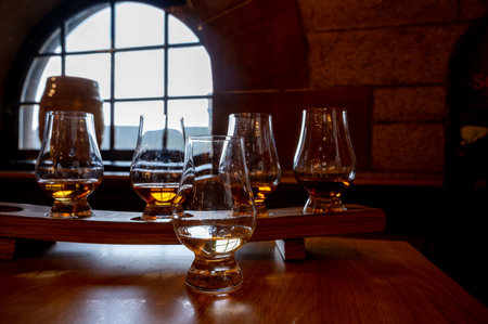 Flight of single malt scotch whiskey in glasses served in bar in Edinburgh, UK, tasting of dram of whiskeyの写真素材