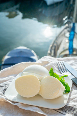 Tasting of white soft italian balls mozzarella cheese made from buffalo cow milk, served outdoorの写真素材