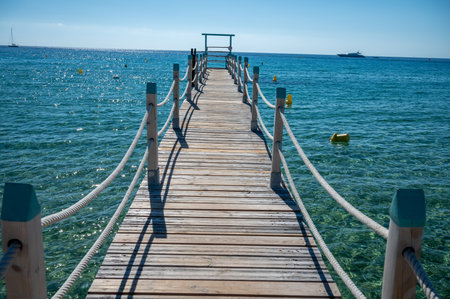 Wooden pier for guests of yachts on legendary Pampelonne beach near Saint-Tropez, summer vacation on white sandy beach of French Riviera, Franceの写真素材