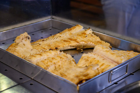 Cod fish salted bacalhau grilled on olive wood firewood grill in small village restaurant in...