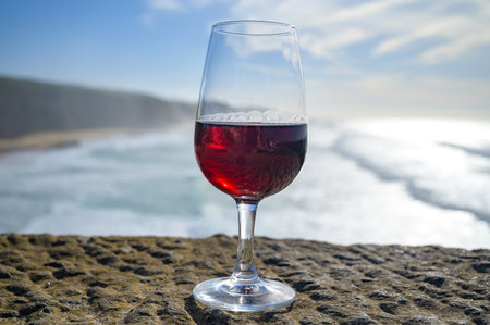 Tasting of tawny porto wine and view on sandy beach and blue Atlantic ocean near Sintra in Lisbon area, wine of Portugalの写真素材