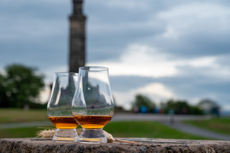 Tasting of single malt scotch whiskey in glasses with panoramic view from Calton hill to new and old parts of Edinburgh city in rainy summer day, Scotland, UKの写真素材
