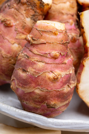 Group of fresh uncooked topinambur or Jerusalem artichoke roots close up