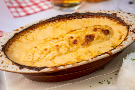 Quenelle, specialty of Lyon, oval-shaped dumplings filled with pike white fish served in creamy sauce in traditional Lyonnaise Bouchon, France, close upの写真素材