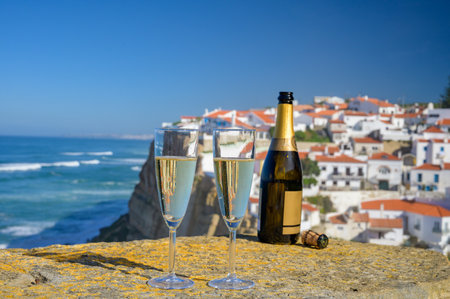 Glasses of champagne sparkling white wine and view on white houses of picturesque village Azenhas do mar, Lisbon area, Portugalの写真素材