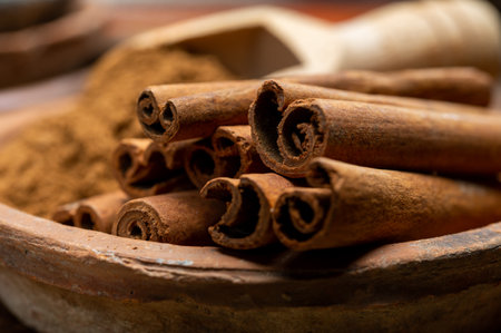 Indian spices collection, dried aromatic cinnamon barks and another spices in clay bowls close upの写真素材
