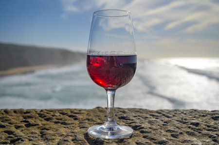 Tasting of tawny porto wine and view on sandy beach and blue Atlantic ocean near Sintra in Lisbon area, wine of Portugalの写真素材