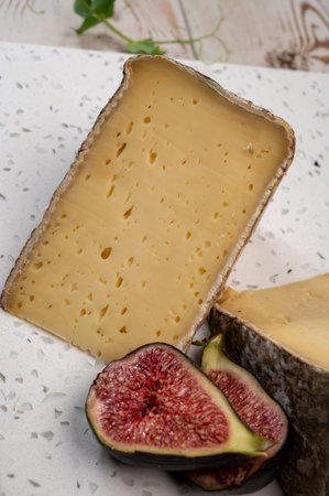 Pieces of cheese tomme de montagne or tomme de savoie made from cow milk in French Alps close up...