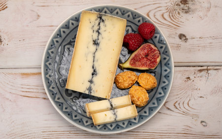 French semi-soft cow milk cheese morbier from Franche-Comte region with thin black layer and strong...