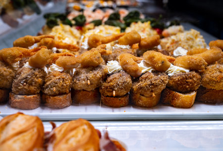 Typical snack of Basque Country, pinchos or pinxtos, small piece of bread with different fish and sea food toppings, served in bar in San-Sebastian or Bilbao, Spainの写真素材