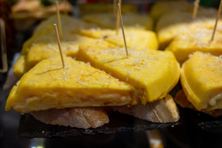 Typical snack of Basque Country, pinchos or pinxtos, small piece of bread with egg omelette and different toppings, served in bar in San-Sebastian or Bilbao, Spainの写真素材