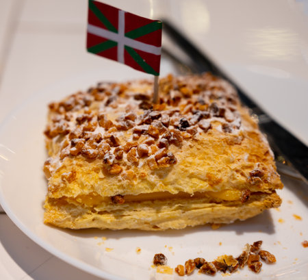 Basque Country food, sweet dessert, puff pastry cake with vanilla cream and hazelnut and flag of Basque Country close up, Spainの写真素材