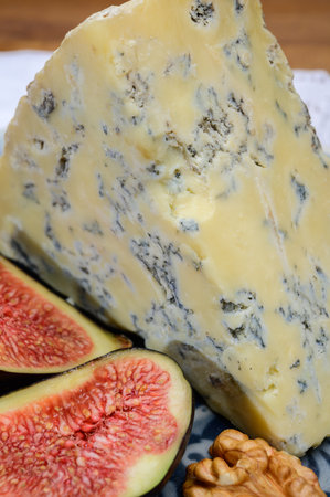 Cheese collection, English old stilton blue cheese close up served with fresh figs