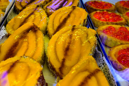 Baked sweet desserts cakes on display in balery in Lisbon, Portugal, close up