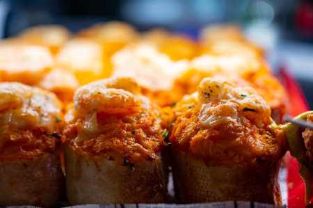 Typical snack of Basque Country, pinchos or pinxtos skewers with small pieces of bread, sea food, eggs, cheese, jamon served in bar in San-Sebastian or Bilbao, Spain, close upの写真素材