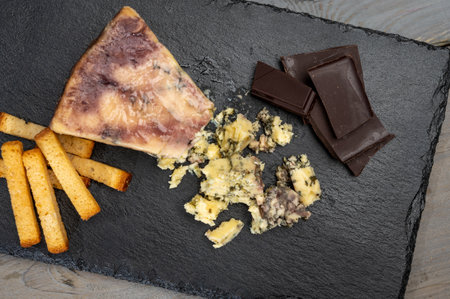 Cheese collection, blue stilton English cheese matured in red porto wine served as dessert with walnuts and chocolate close upの写真素材