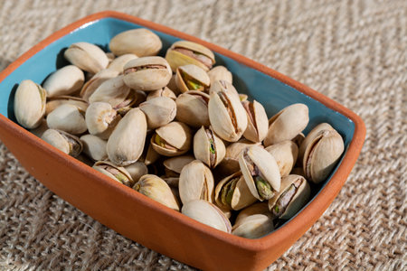 Roasted salty pistachio nuts, tasty healthy vegetarian snack food