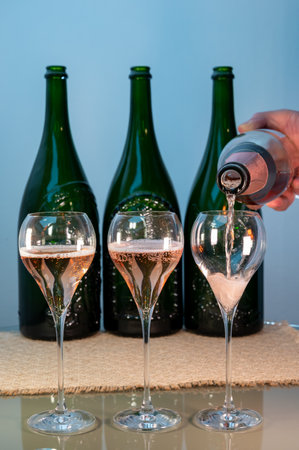 Tasting of rose brut Champagne sparkling wine in cellars of gran cru wine house in Epernay, wine tour in Champagne, France, magnum bottles on backgroundの写真素材