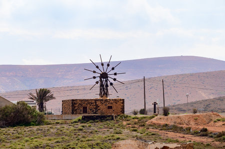 Old traditional Canarian grain wind mill near Antigua village, countryside landscape of Fuerteventura island, Canary islands, Spainの写真素材