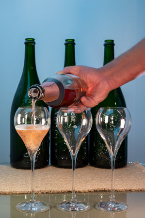Tasting of rose brut Champagne sparkling wine in cellars of gran cru wine house in Epernay, wine tour in Champagne, France, magnum bottles on backgroundの写真素材