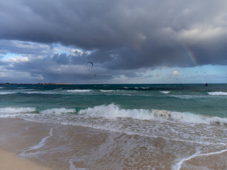 Sunset view on white sandy Corallejo beach, Atlantic ocean water waves and kite surfers at winter, Fuerteventura, Canary islands, Spainの写真素材