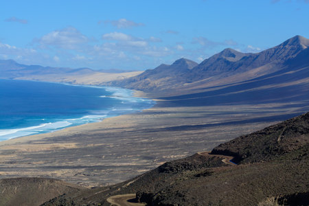View on difficult to access golden sandy long Cofete beach hidden behind mountain range on Fuerteventura, Canary islands, Spainの写真素材