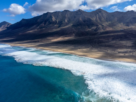 Aerial view on difficult to access golden sandy long Cofete beach hidden behind mountain range on Fuerteventura, Canary islands, Spainの写真素材