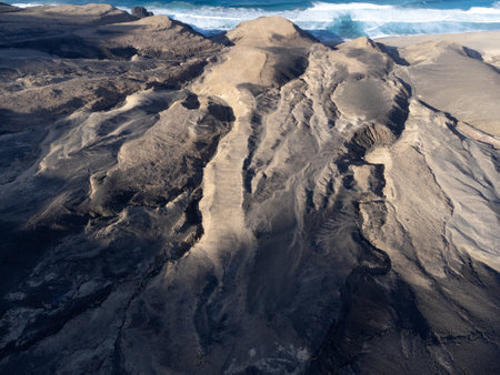 Aerial view on difficult to access golden sandy long Cofete beach hidden behind mountain range on Fuerteventura, Canary islands, Spainの写真素材