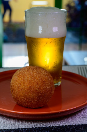 Traditional street food in Scotland, glass of fresh lager beer and stuffed fried Scotch eggs with breadcrumbsの写真素材