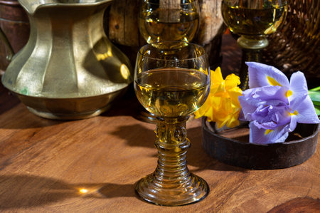 Antique German glassware, old Dutch style rummer or rummer glasses for white riesling wine and colorful flowers on tableの写真素材