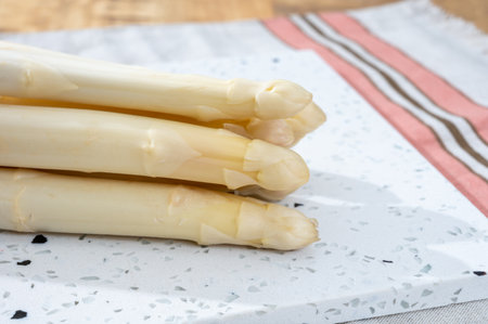 Spring season, new harvest of Dutch, German white asparagus, bunch of raw white asparagus on tableの写真素材