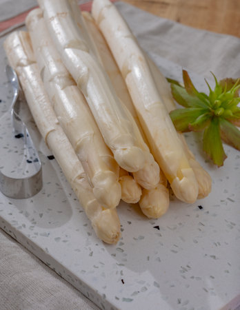 Spring season, new harvest of Dutch, German white asparagus, bunch of raw white asparagus on tableの写真素材