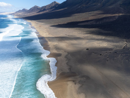 Aerial view on difficult to access golden sandy long Cofete beach hidden behind mountain range on Fuerteventura, Canary islands, Spainの写真素材