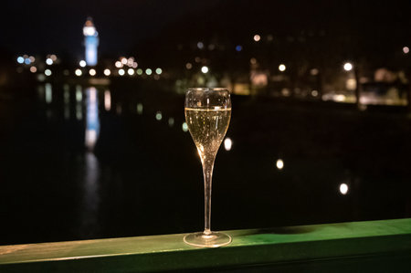 Tasting of french sparkling white wine with bubbles champagne outdoor at night with view on Marne river and lights of Epernay city in winter, Franceの写真素材
