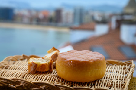 Spanish hard smoked cow cheese from Pria, Asturias, served outdoor with view on San Lorenzo beach...
