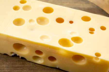 Cheese collection, block of french hard cheese with holes emmentaler close upの写真素材