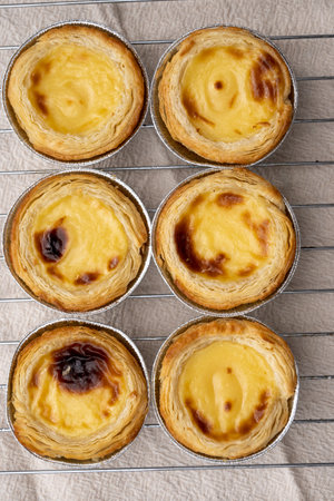 Portugal's traditional sweet dessert Pastel de nata egg custard tart pastry in cup close up