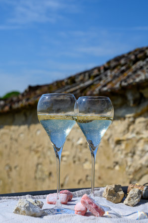 Tasting of grand cru sparkling white wine with bubbles champagne with view on old houses of Oger, small village with grand cru vineyards, Champagne, France.の写真素材