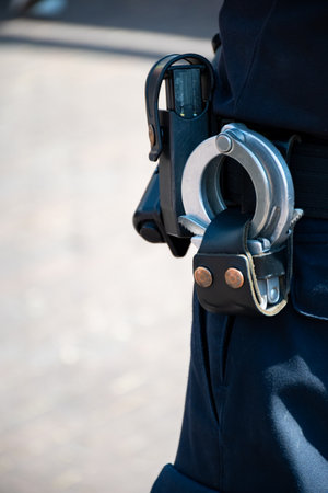 Police officer, policeman with handcluffs on belt, clime prevention, close-up