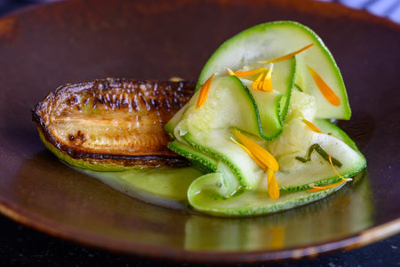 Exquisite vegetarian zucchini dish of modern French haute cuisine prepared with fresh organic ingredients from restaurant own garden and farm and beautifully served with sauceの写真素材