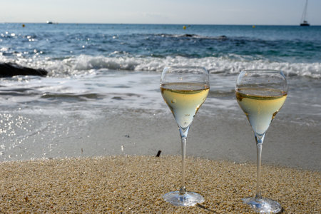 Summer time in Provence, two glasses of cold champagne cremant sparkling wine on sandy beach near Saint-Tropez in sunny day, Var department, vacation in Franceの写真素材